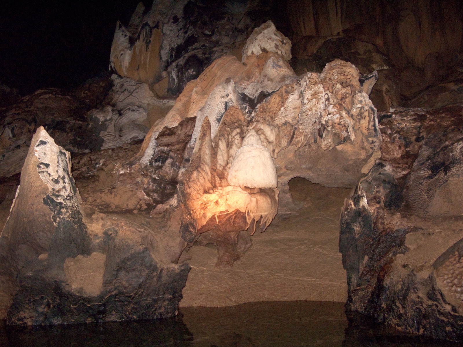 A dense cluster of stalactites hanging from the ceiling and stalagmites rising from the floor inside the Puerto Princesa Subterranean River cave in Palawan, Philippines