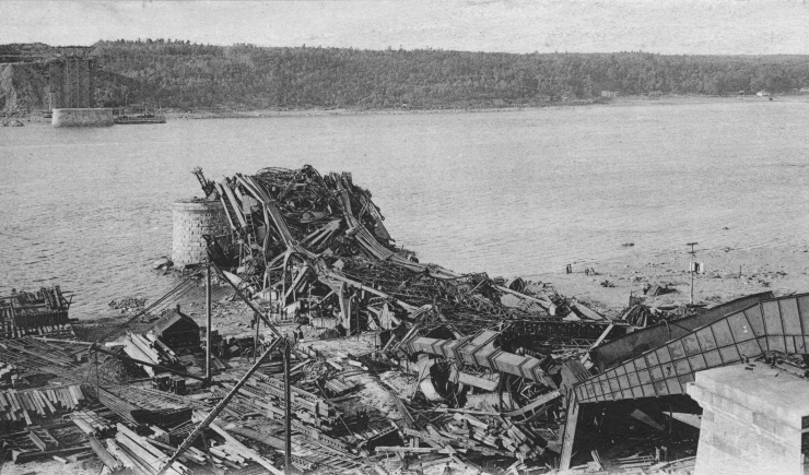 A 1907 photograph of the collapsed Quebec Bridge, showing the twisted wreckage of the cantilever truss span after it fell into the St. Lawrence River